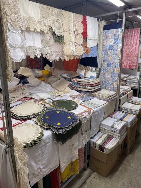 Stall of hand-embroidered lace tablecloths and linens at a Brazilian market